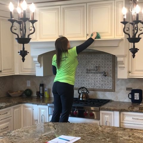 ez pizzi cleaning employee cleans above stove mantle