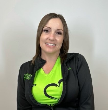 A woman wearing a green t - shirt and black jacket.