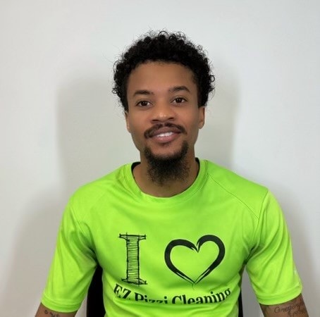 A man wearing a green shirt with a heart on it.