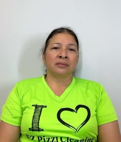 A woman wearing a green shirt with a heart on it.